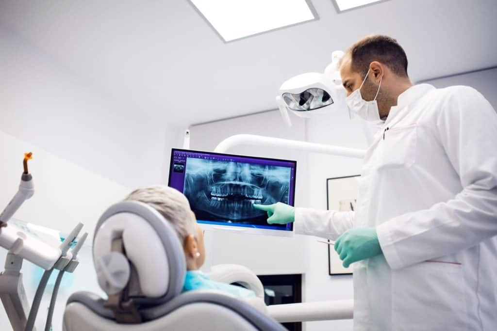 Dentist reviewing digital dental X-rays with a patient