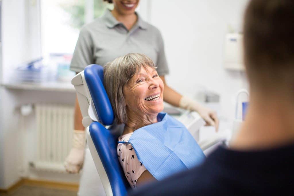 Happy senior female patient smiling during a dental check-up 