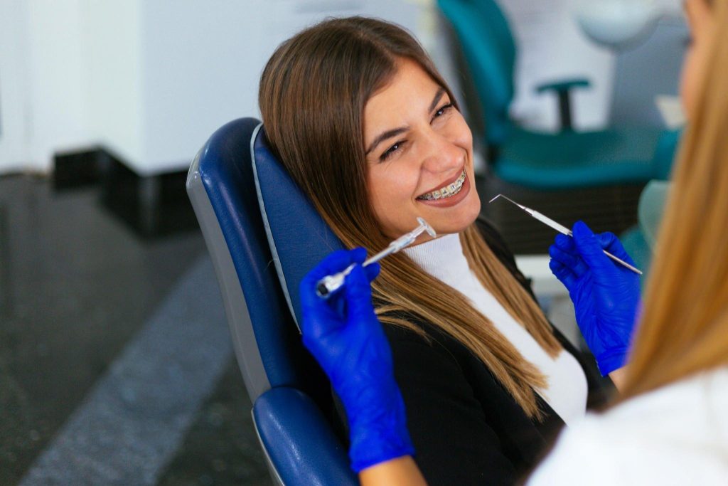 Female patient with orthodontic braces receiving dental care